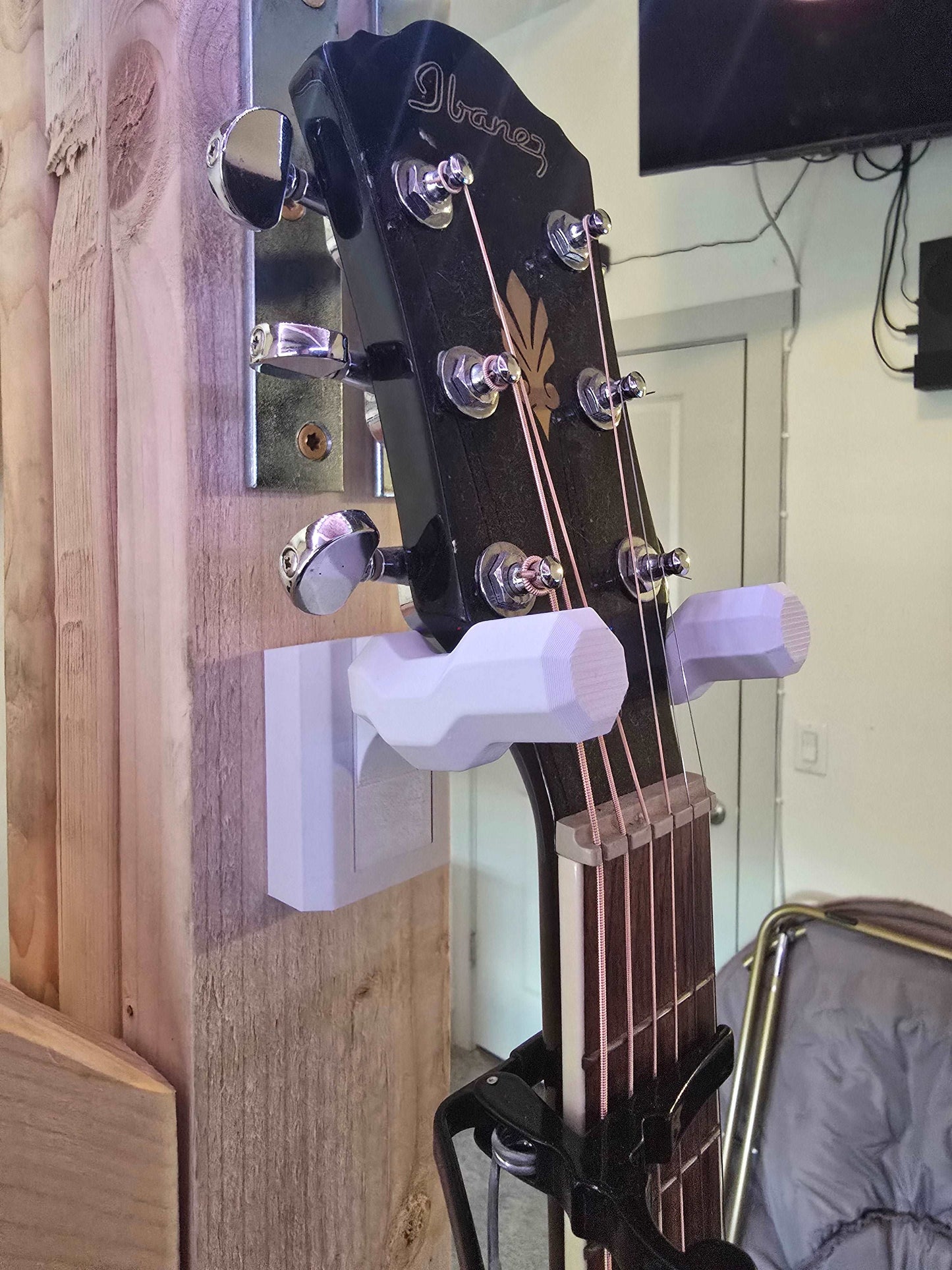 Guitar Hook Holder Wall Mount Bracket
This wall-mounted guitar holder securely displays and stores a black electric guitar, allowing easy access and showcasing the instrument in a stylish way.