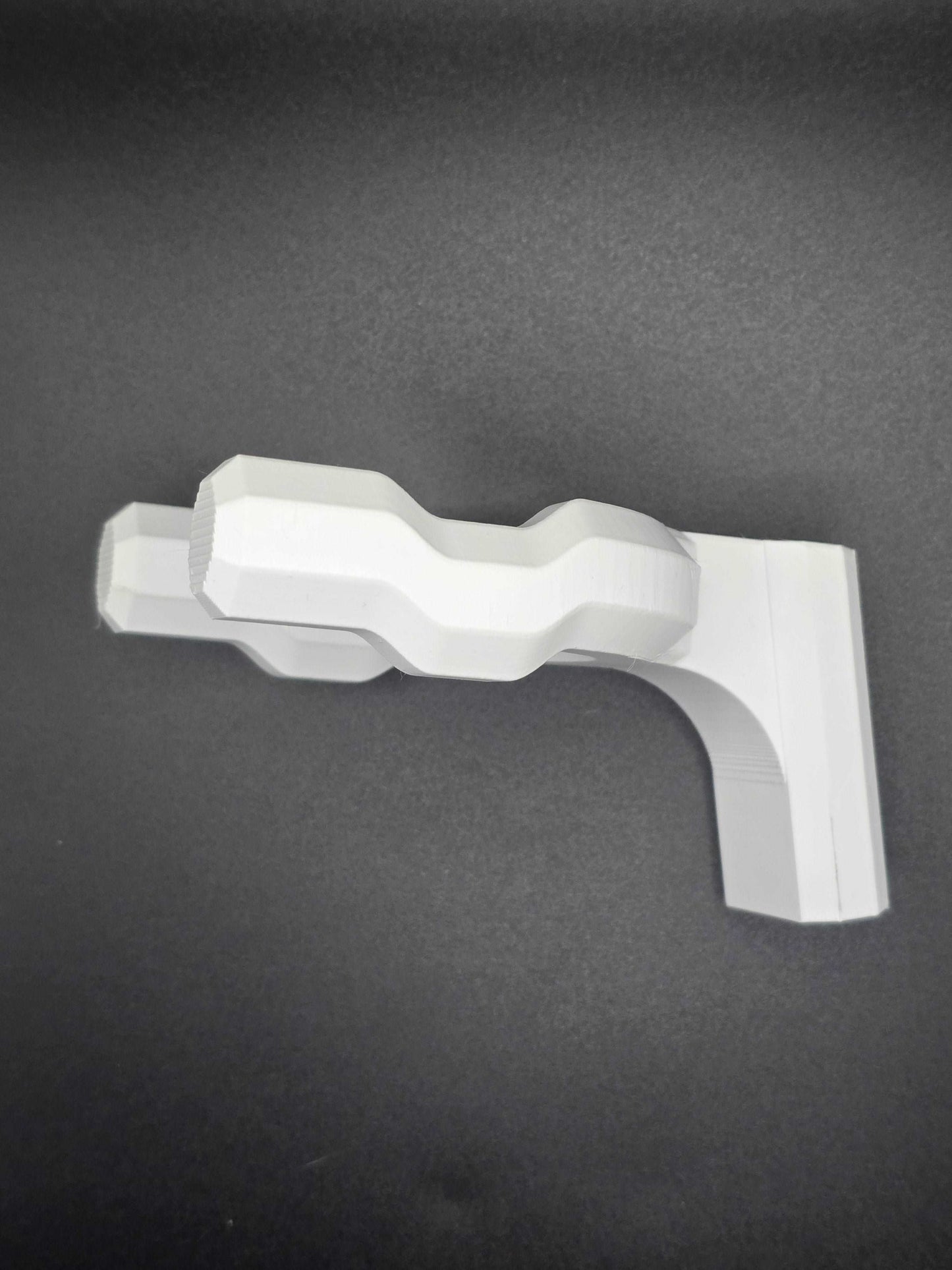 Wall-mounted geometric guitar holder in white, designed to securely display and store a guitar on the wall.