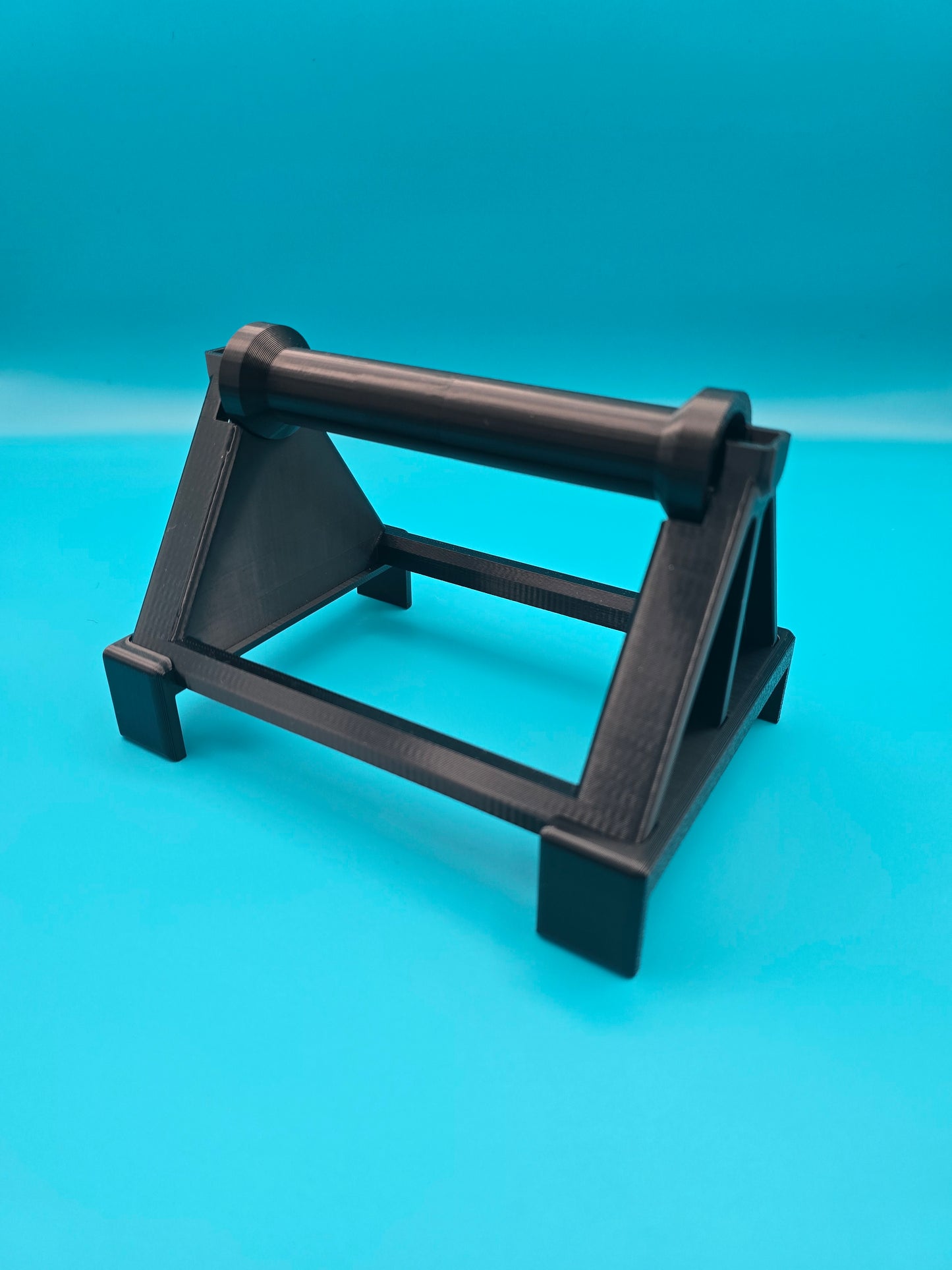 Sturdy black desktop stand for thermal label printer spool, designed for efficient organization and smooth printing operation.