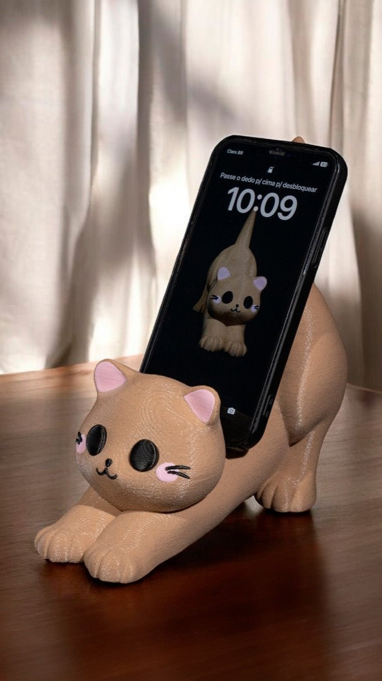 Adorable plush cat holding smartphone with cartoon cat design on screen, placed on wooden surface