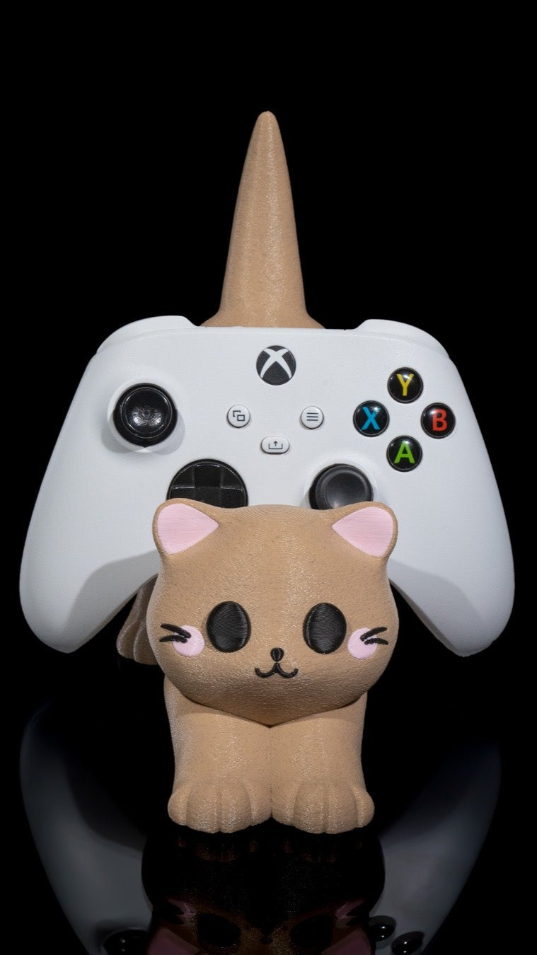 Adorable cat-shaped multipurpose holder displayed with a white video game controller on a reflective black surface