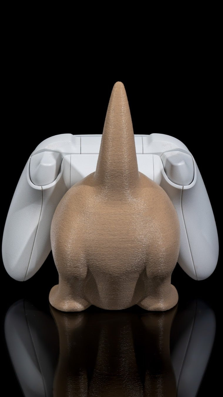 Sleek white gaming controller and quirky beige cat figure on mirrored surface