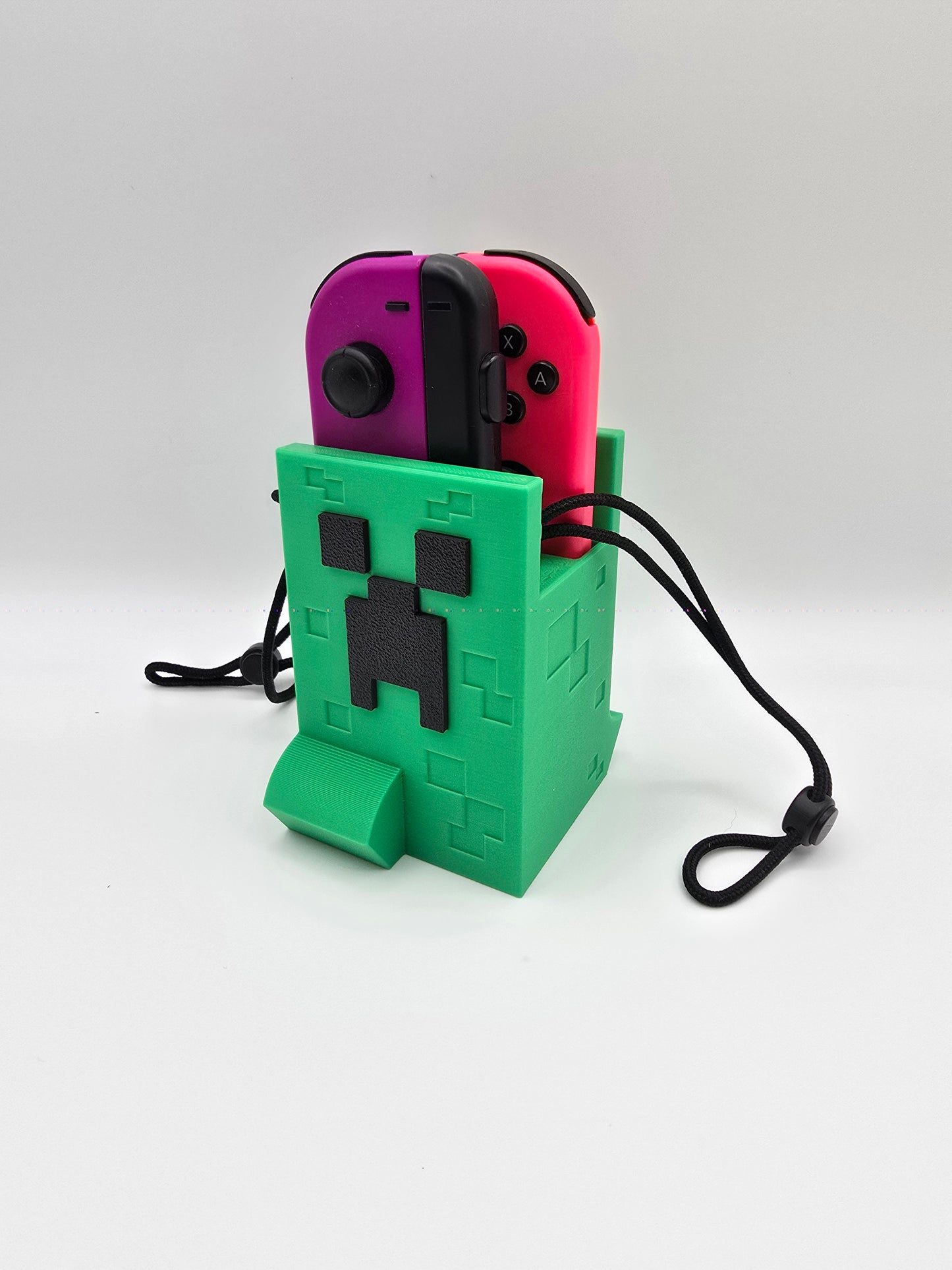 3D printed Minecraft Creeper Nintendo Switch controller and Joy-con holder in vibrant pink and green colors