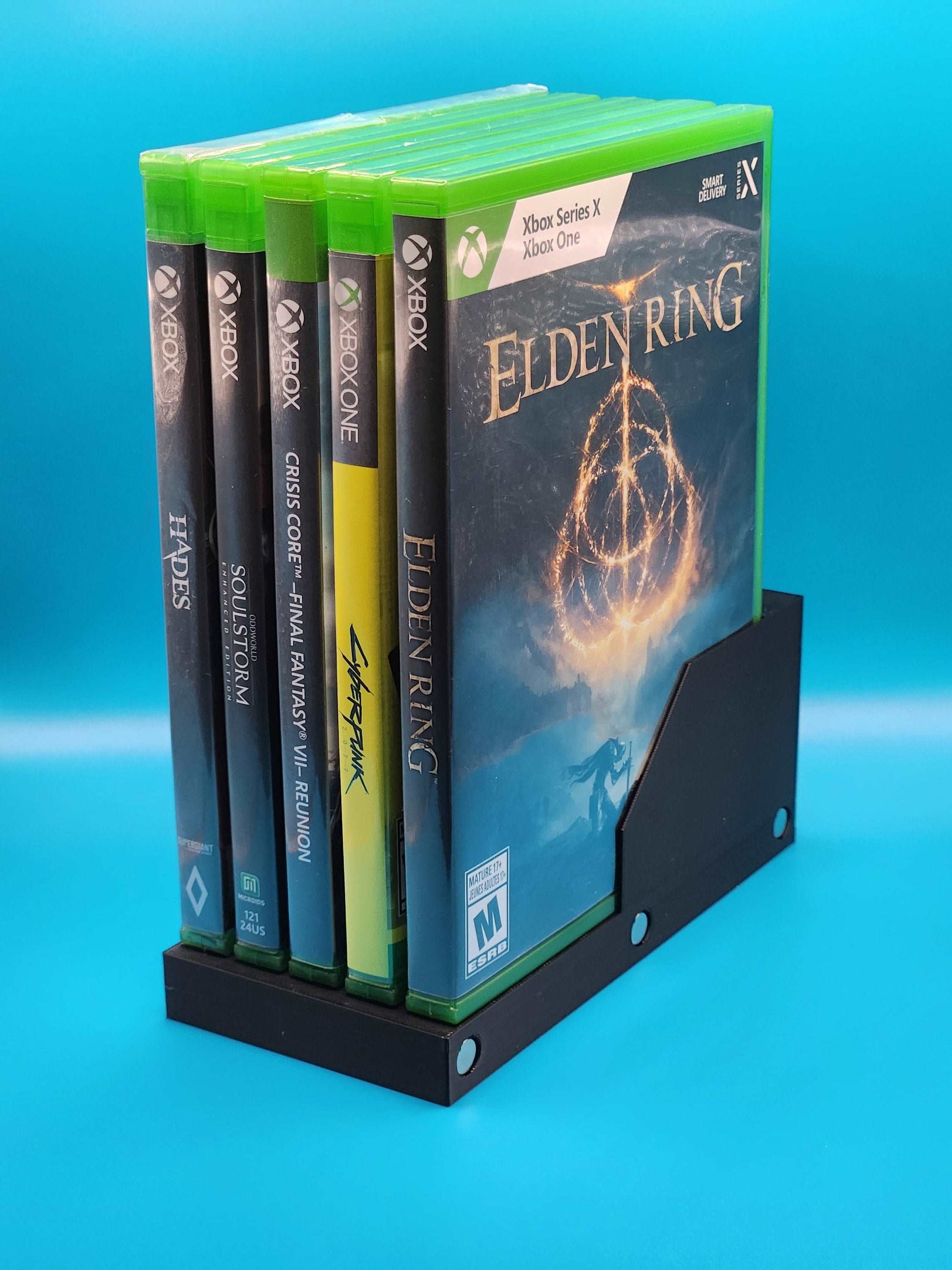 Modular game case stand with magnetic Xbox game cases, showcasing Elden Ring video game cover art.