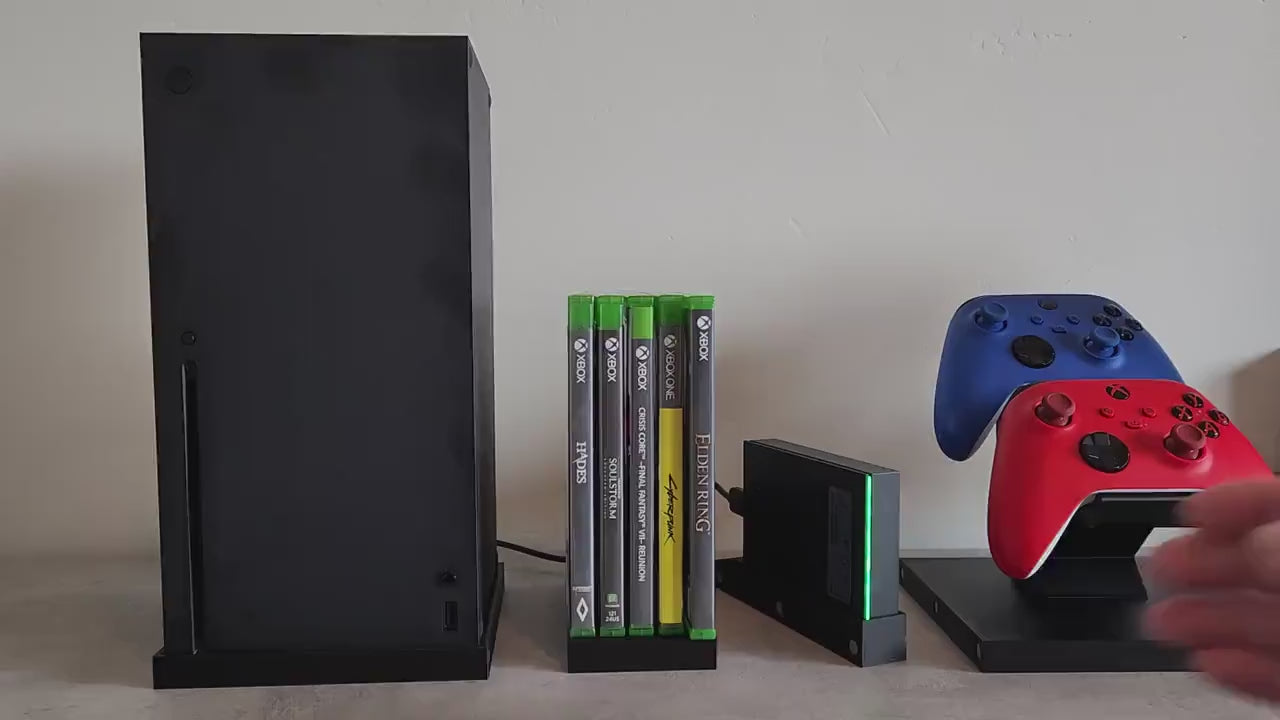 Innovative video game console organizer system with modular magnetic design, showcasing XBox console, controllers, and game cases on a white background.